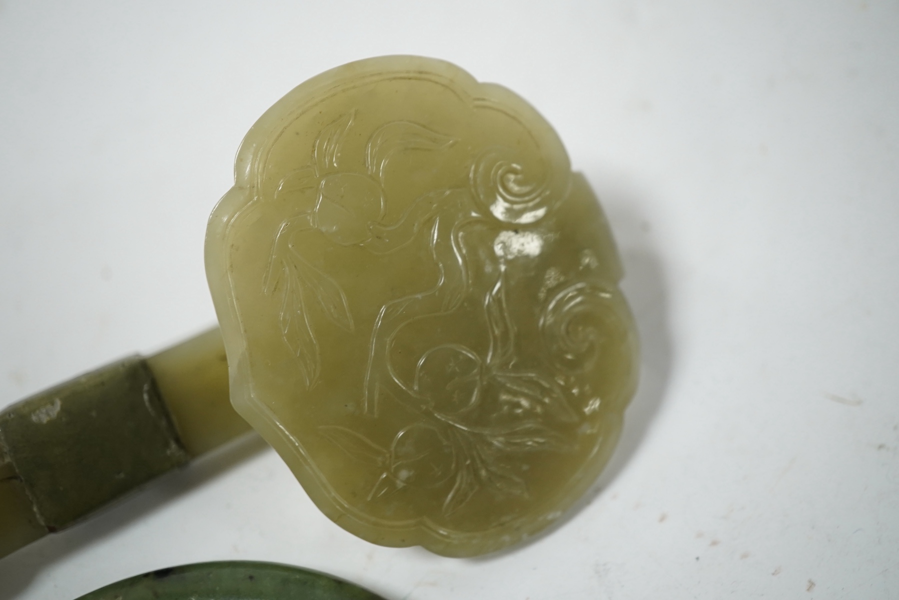 A Chinese celadon jade ruyi sceptre (incomplete) and a spinach jade bangle, late Qing, largest 15.5cm in length (2). Condition - bangle good